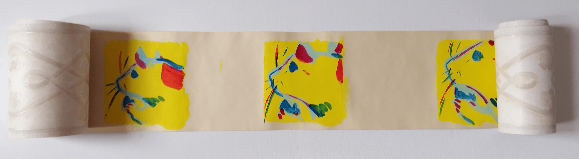 A photo of a roll of wallpaper. The wallpaper roll is opened and the inside has been painted with yellow squares, three are visible. Inside the squares are simple close-up paintings of a rat.