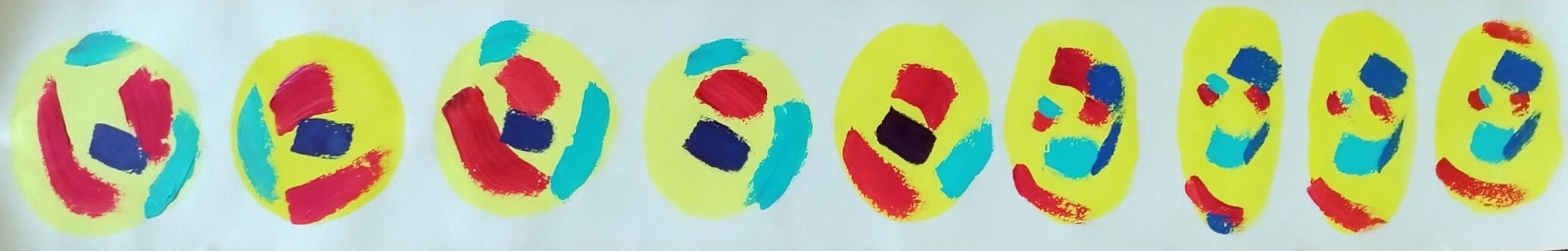 A photo of a roll of wallpaper. The wallpaper roll is opened and the inside has been painted with yellow blobs. Inside the blobs are abstract and colorful shapes.